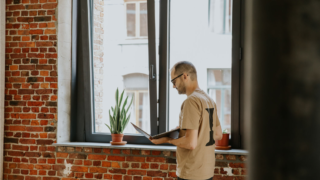 A data analyst working on a laptop in a modern office environment.