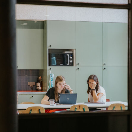 Two women working on AI solutions in a collaborative workspace.